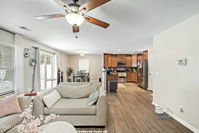 living room with ceiling fan and light hardwood / wood-style floors