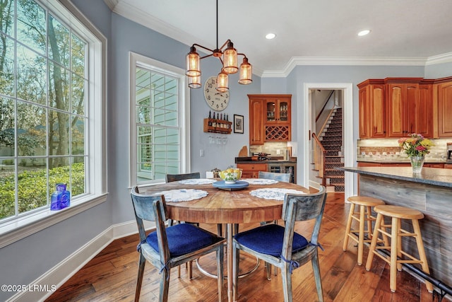 dining space featuring hardwood / wood-style flooring and ornamental molding