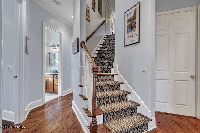 staircase with crown molding and hardwood / wood-style flooring