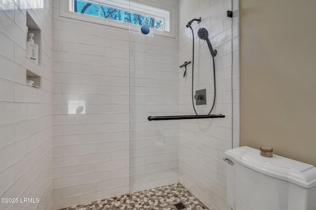 bathroom with tiled shower and toilet