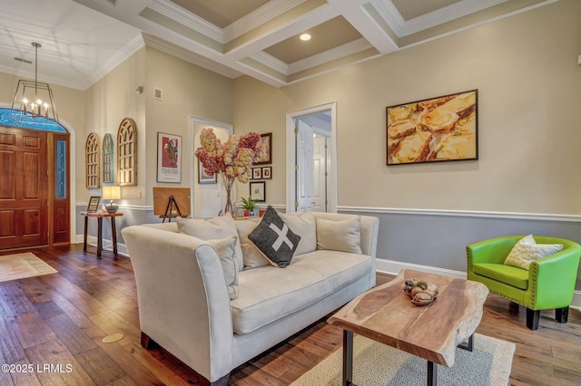 living room featuring coffered ceiling, an inviting chandelier, ornamental molding, beam ceiling, and hardwood / wood-style floors