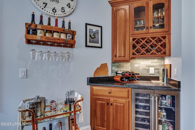 bar featuring beverage cooler, decorative backsplash, and dark stone countertops