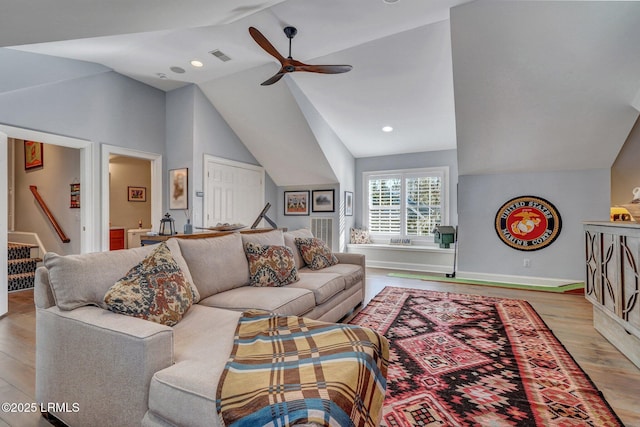 living room with light hardwood / wood-style flooring, vaulted ceiling, and ceiling fan