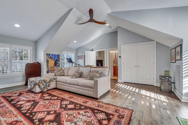 living room featuring hardwood / wood-style flooring, vaulted ceiling, and ceiling fan