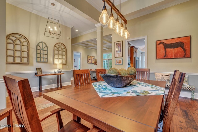 dining space with crown molding, hardwood / wood-style floors, and an inviting chandelier