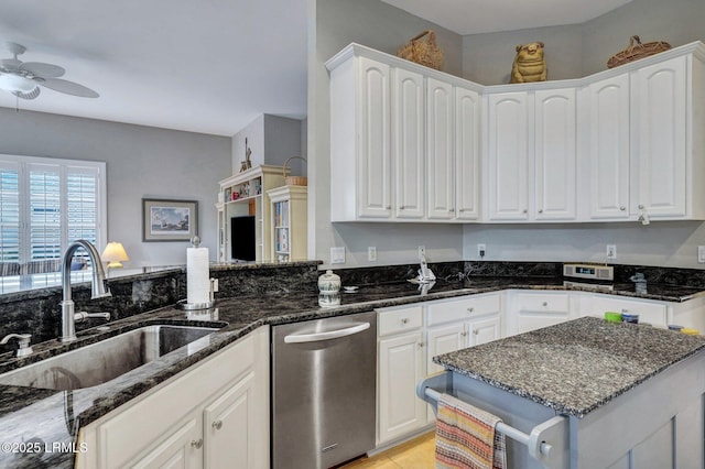 kitchen featuring sink, dishwasher, dark stone counters, and white cabinets