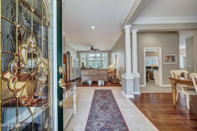 tiled entrance foyer with ornamental molding, ceiling fan, and ornate columns