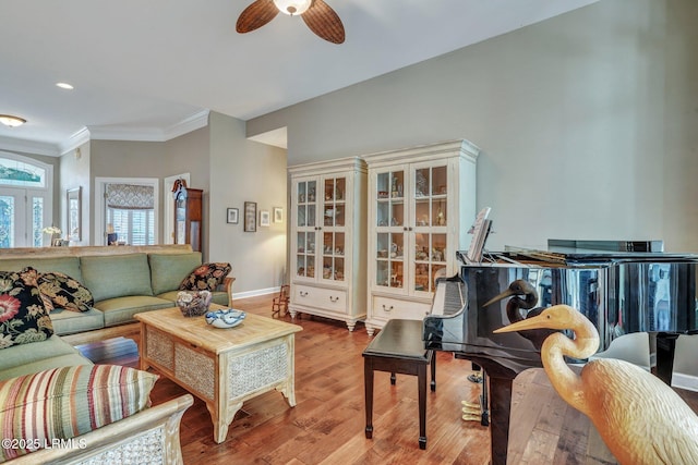 living room featuring crown molding, light hardwood / wood-style flooring, and ceiling fan