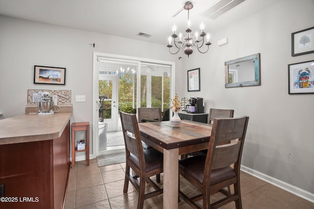 dining area featuring a chandelier, tile patterned flooring, visible vents, and baseboards