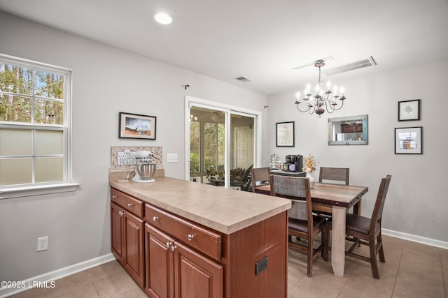 kitchen featuring a chandelier, light countertops, a healthy amount of sunlight, and a peninsula