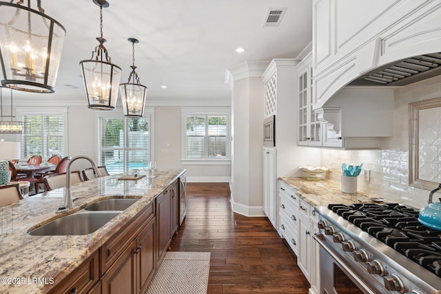 kitchen featuring pendant lighting, white cabinetry, sink, a notable chandelier, and stainless steel appliances