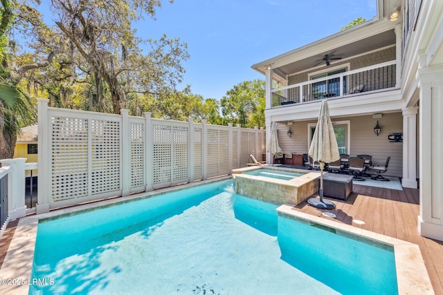 view of swimming pool with an in ground hot tub, ceiling fan, and a wooden deck