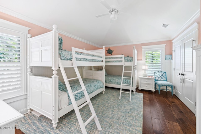 unfurnished bedroom with crown molding, ceiling fan, dark wood-type flooring, and vaulted ceiling