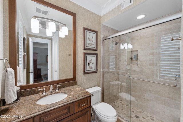 bathroom with a shower with door, crown molding, vanity, and toilet