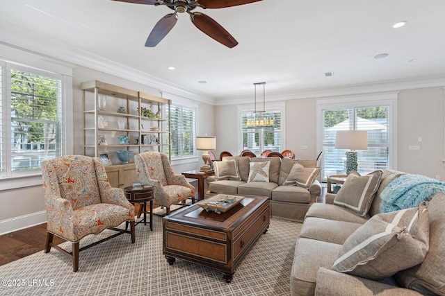 living room featuring crown molding, a healthy amount of sunlight, ceiling fan, and light wood-type flooring