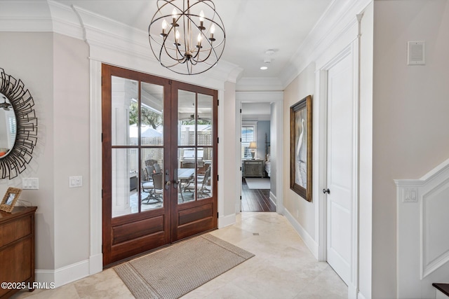 foyer featuring french doors, crown molding, and a notable chandelier