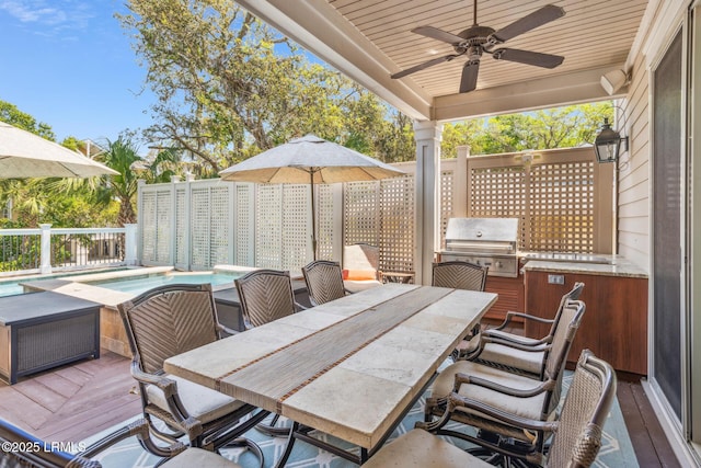 wooden deck featuring ceiling fan, grilling area, and a fenced in pool