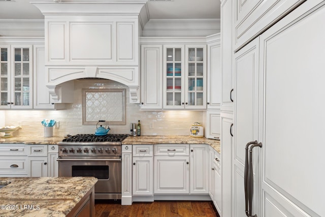 kitchen featuring crown molding, light stone countertops, white cabinets, and high end range