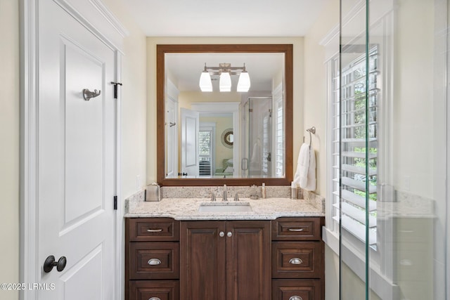 bathroom with a shower with door and vanity