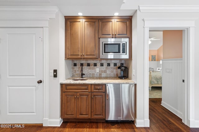 kitchen with dark wood-type flooring, sink, tasteful backsplash, stainless steel appliances, and light stone countertops