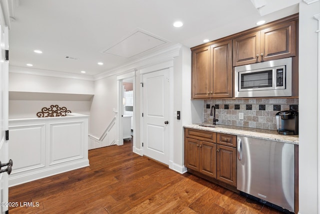 kitchen with sink, dishwasher, dark hardwood / wood-style floors, stainless steel microwave, and light stone counters