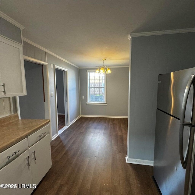 907 Duke St, Beaufort, SC 29902 - kitchen with dark wood-style flooring, a chandelier, crown molding, white cabinetry, and freestanding refrigerator