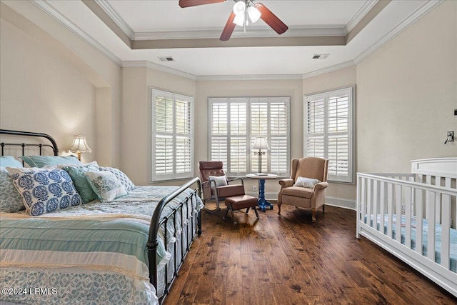 bedroom with multiple windows, a raised ceiling, and ceiling fan