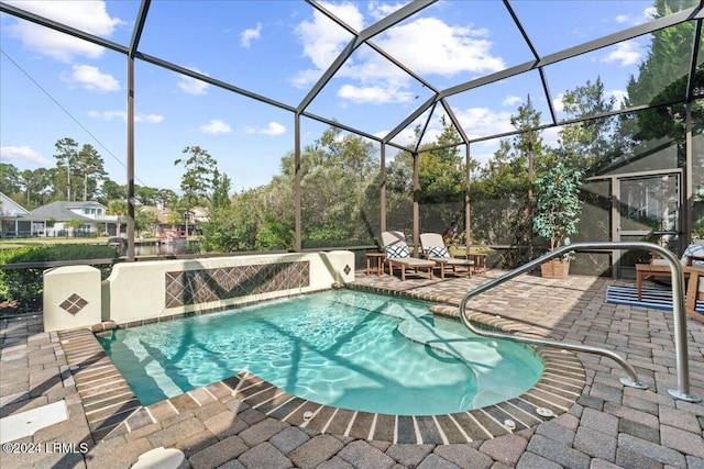 view of swimming pool featuring a patio area, pool water feature, and glass enclosure