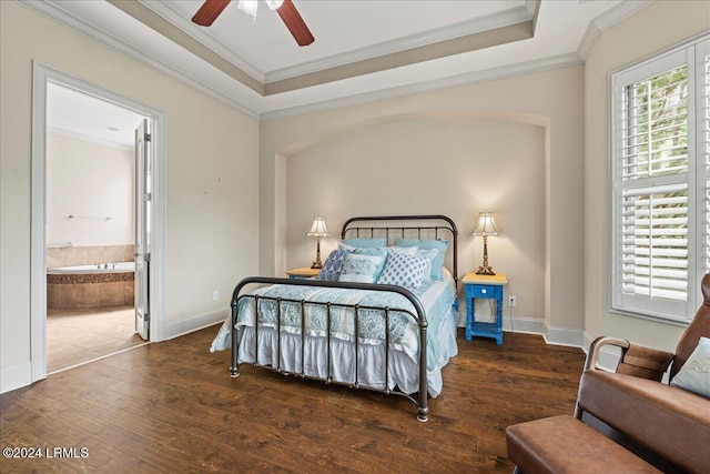 bedroom with crown molding, ensuite bath, dark hardwood / wood-style floors, a raised ceiling, and ceiling fan