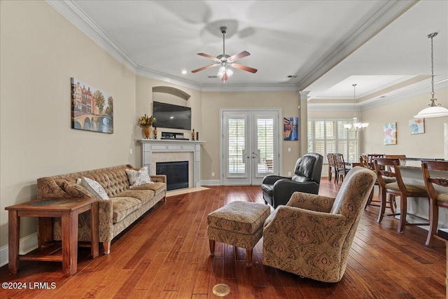 living room featuring ornamental molding, wood-type flooring, ceiling fan with notable chandelier, and french doors