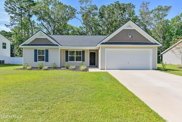 view of front of home with a garage, central AC unit, and a front yard