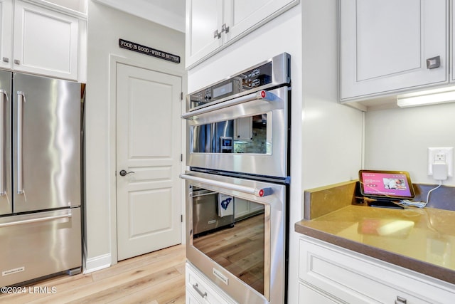 kitchen featuring white cabinetry, appliances with stainless steel finishes, and light wood-type flooring