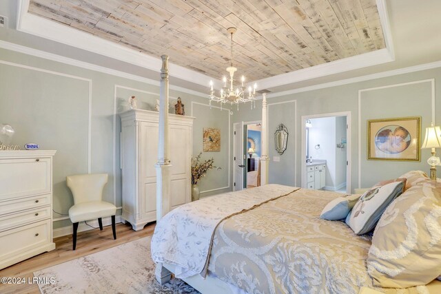 bedroom featuring wood ceiling, ensuite bath, light wood-type flooring, ornamental molding, and a tray ceiling