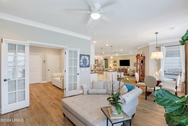 living room featuring sink, crown molding, french doors, and light wood-type flooring