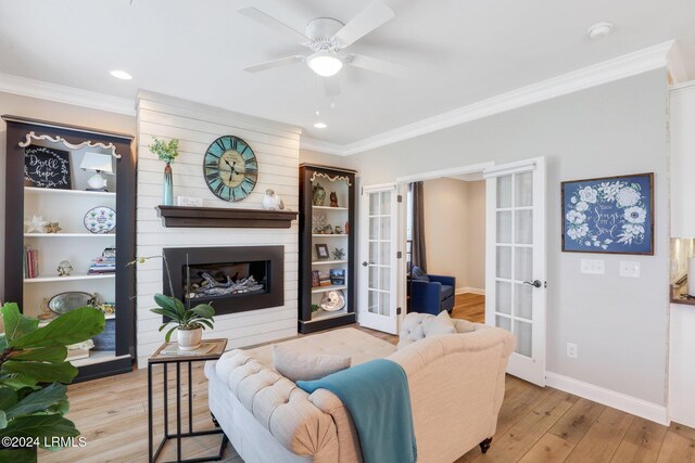 living room with french doors, crown molding, and light wood-type flooring