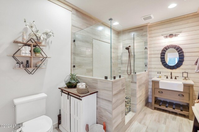 bathroom with vanity, toilet, and a tile shower