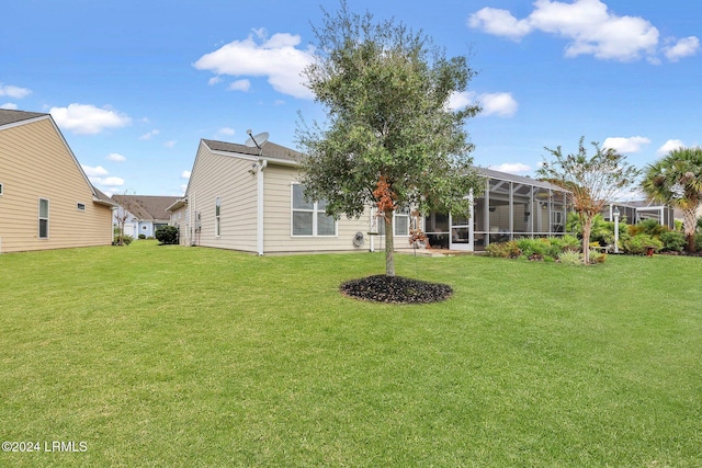 back of property with a lanai and a lawn