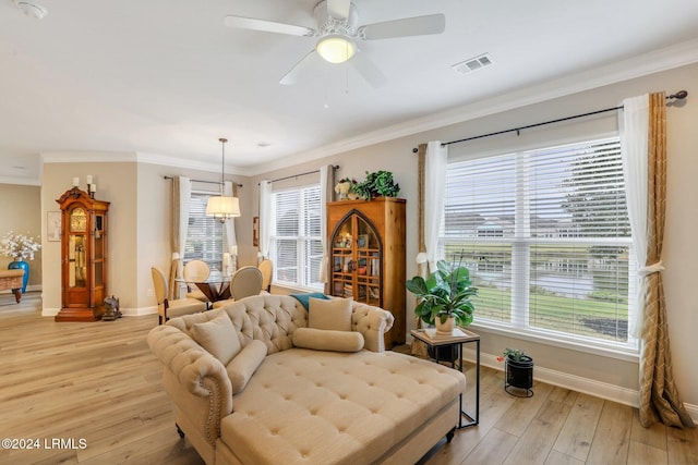 living room with ceiling fan, ornamental molding, and light hardwood / wood-style flooring