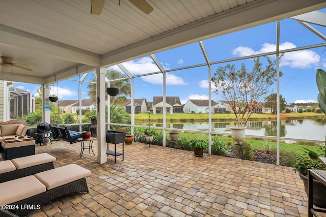 sunroom / solarium with ceiling fan and a water view