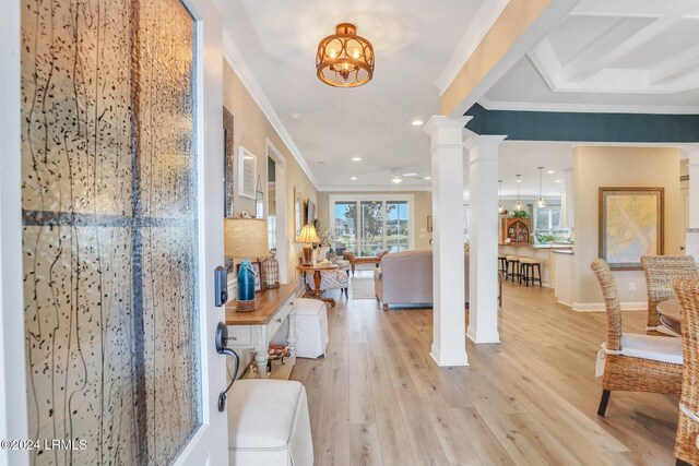 foyer with coffered ceiling, decorative columns, ornamental molding, light hardwood / wood-style floors, and ceiling fan with notable chandelier