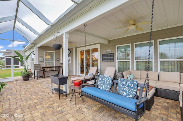 view of patio / terrace with ceiling fan, an outdoor living space, and glass enclosure