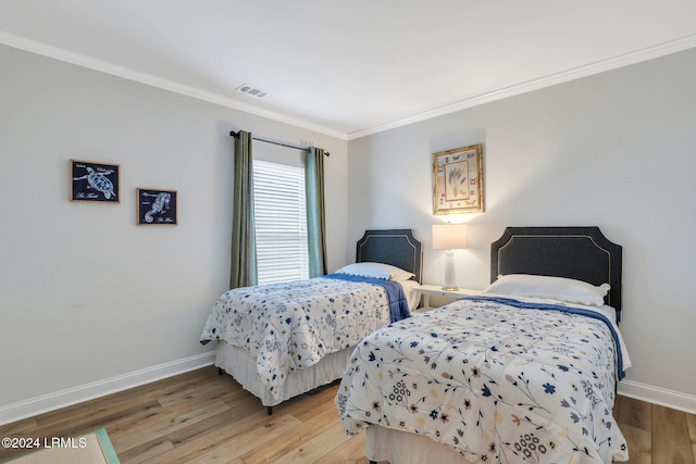 bedroom with crown molding and hardwood / wood-style floors