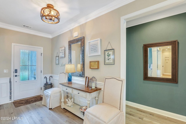 entryway with crown molding, light hardwood / wood-style flooring, and a notable chandelier