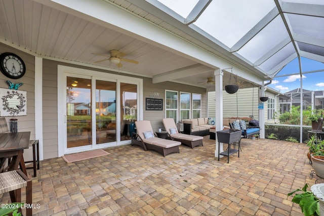 view of patio / terrace featuring ceiling fan, an outdoor living space, and a lanai