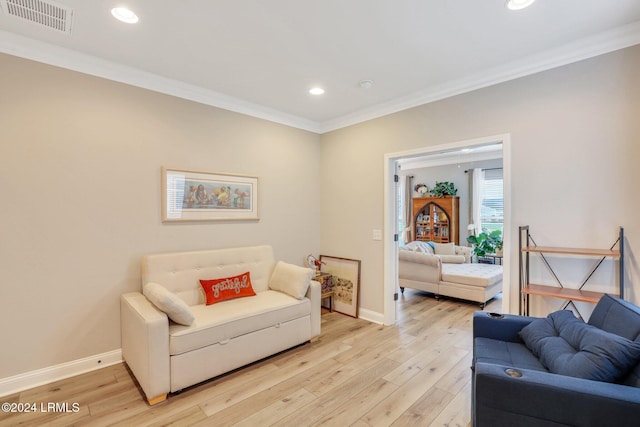 living room with ornamental molding and light wood-type flooring