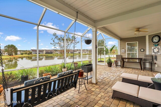 view of patio featuring a water view, ceiling fan, outdoor lounge area, and glass enclosure