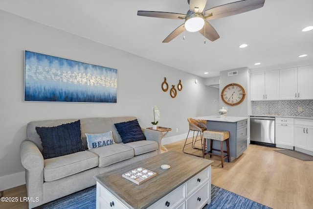 living room with ceiling fan and light hardwood / wood-style flooring