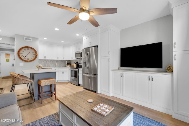 living room featuring light hardwood / wood-style flooring and ceiling fan