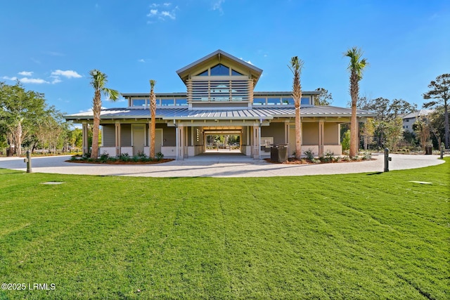 back of property with a carport and a yard