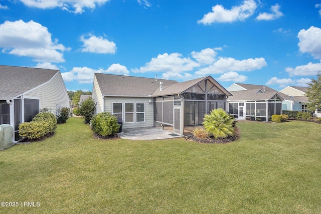 rear view of property featuring a patio area, a sunroom, and a lawn